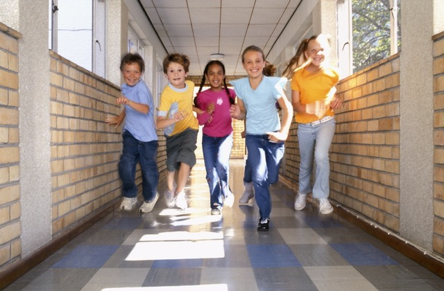 Children run through school hallway
